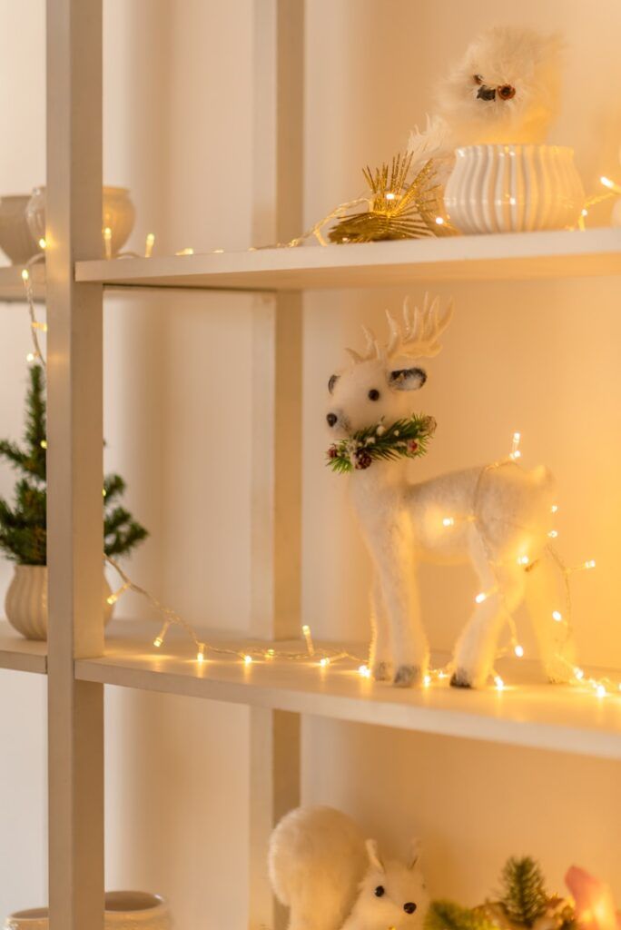 a couple of white deer figurines sitting on top of a white shelf