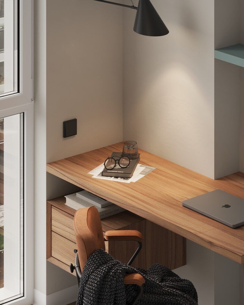 A wooden desk with a laptop on top of it