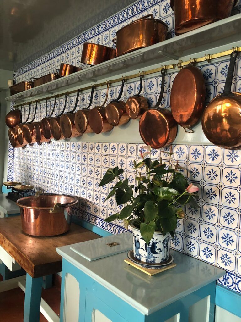 brown and silver cooking pots on white wooden shelf