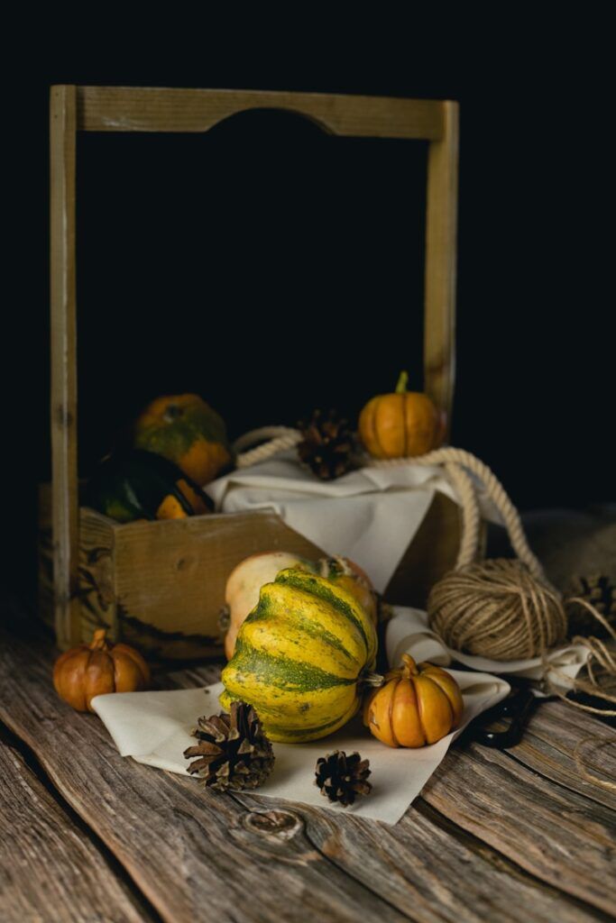 a table topped with pumpkins and pine cones