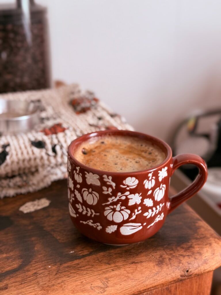A festive mug filled with coffee sits on a wooden surface.