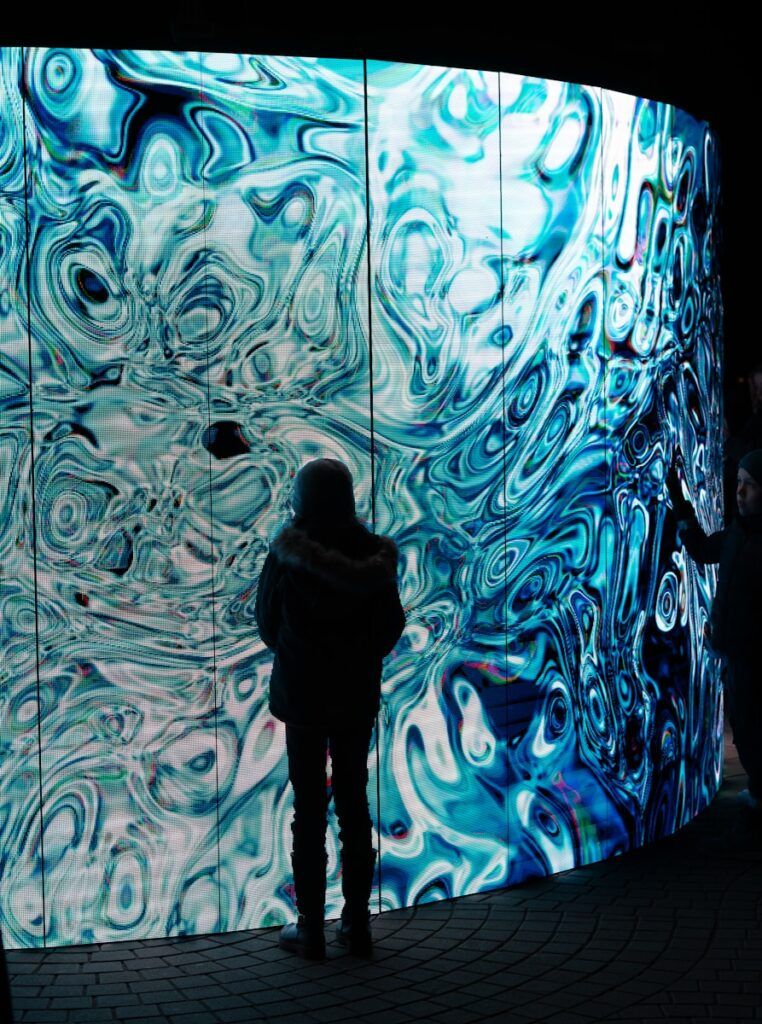 A person standing in front of a large wall