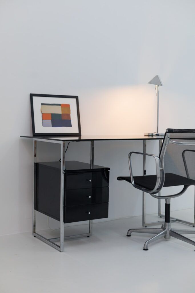 A desk with a chair and a lamp on it