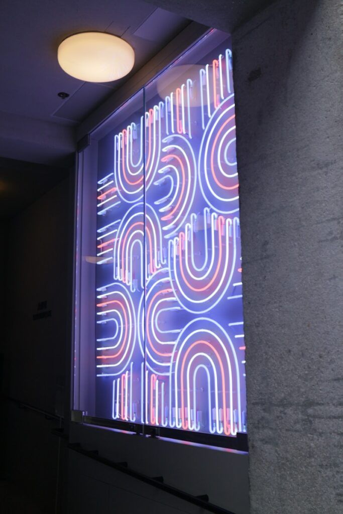 A large window with a neon sign on it