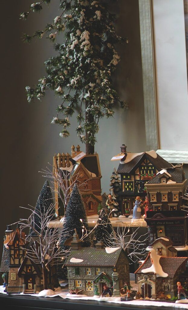 A christmas village with a christmas tree in the background