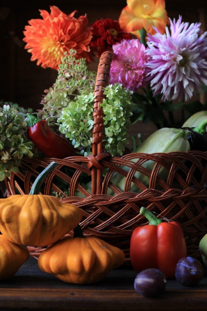 red and yellow bell pepper on brown woven basket