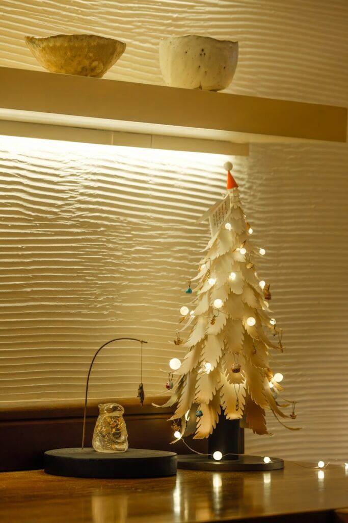 A white christmas tree sitting on top of a wooden table