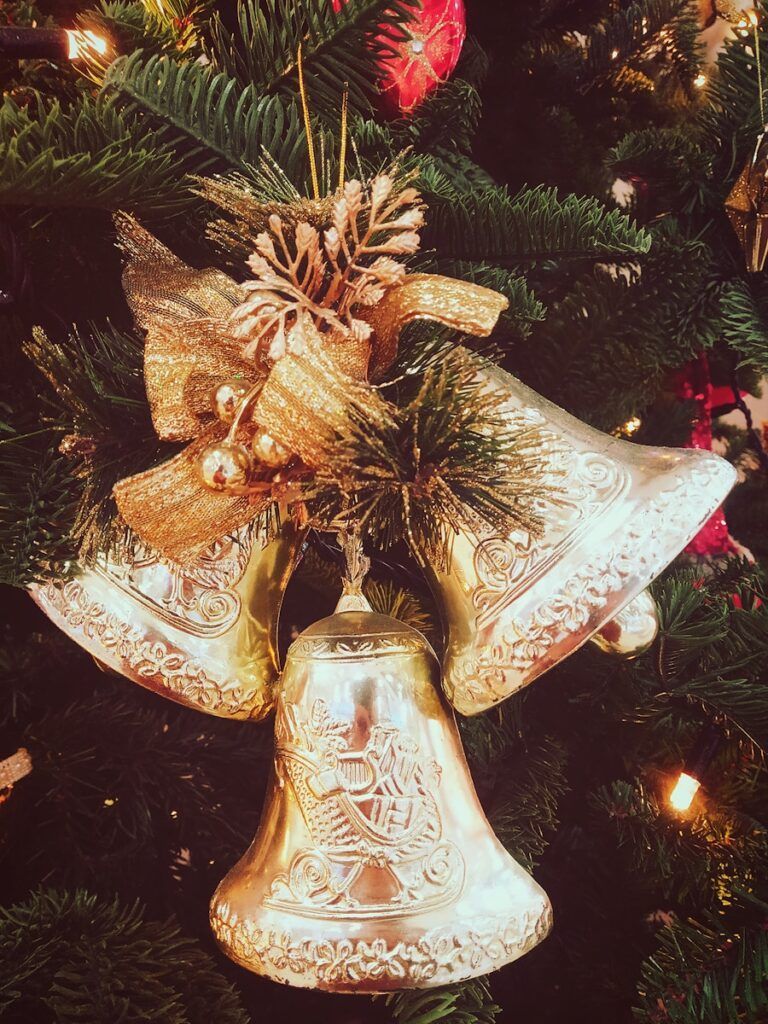 a christmas tree with a gold bell ornament