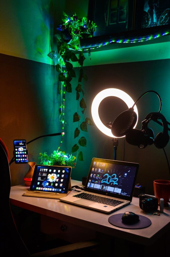 a laptop computer sitting on top of a wooden desk with string lights