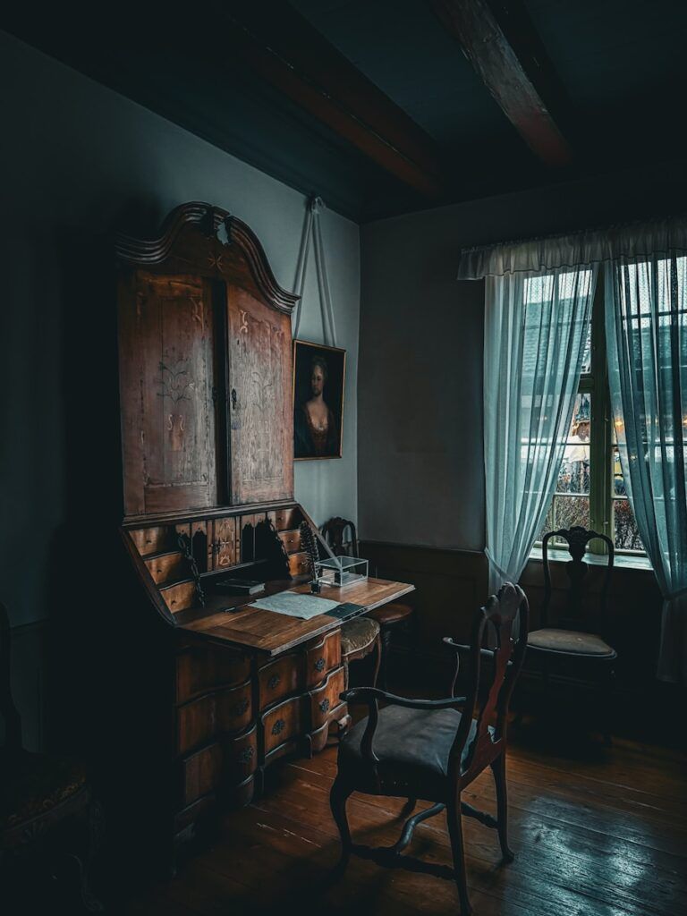 A dark, old-fashioned desk in a dimly lit room.