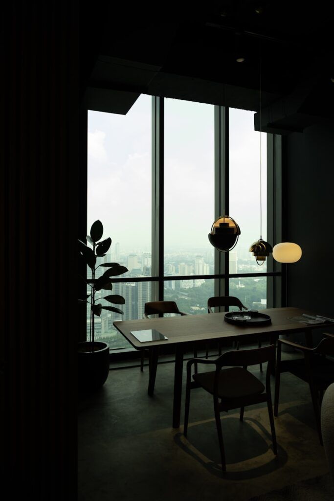 a room with a table, chairs and a large window