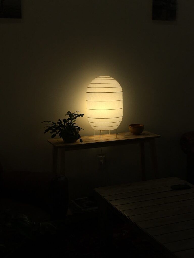A table with a lamp on it in a dark room