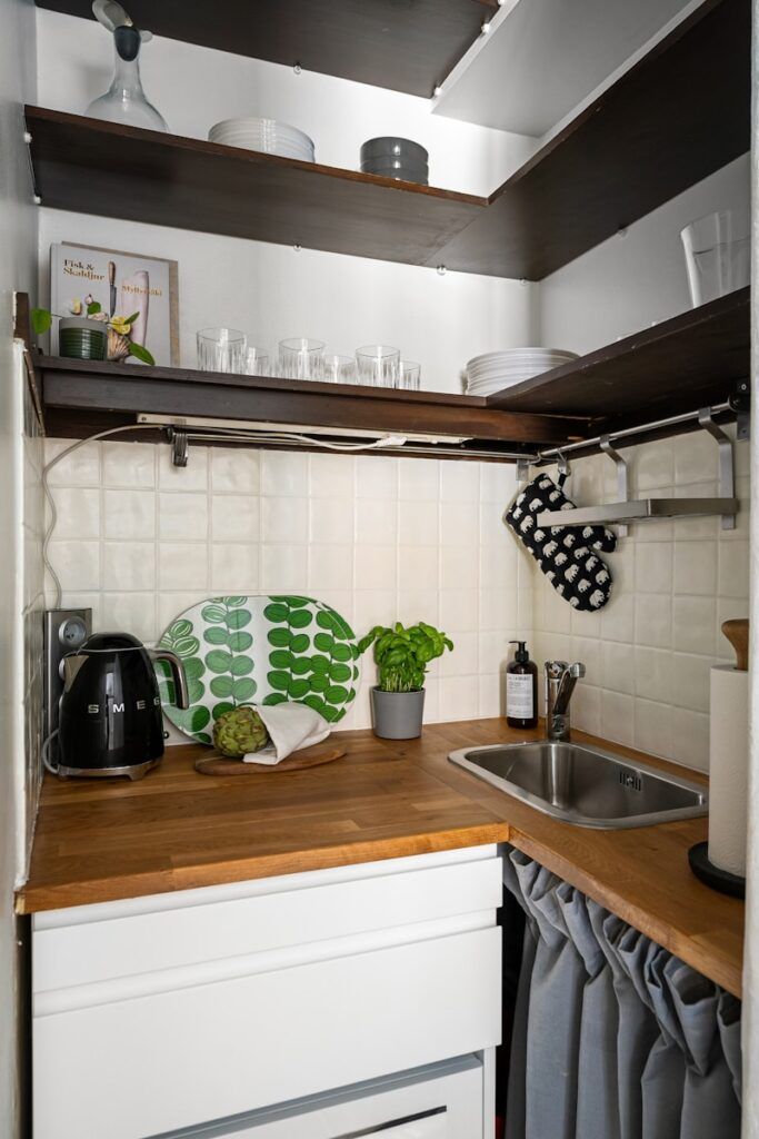 A small kitchen with a sink, dishwasher, and cupboards