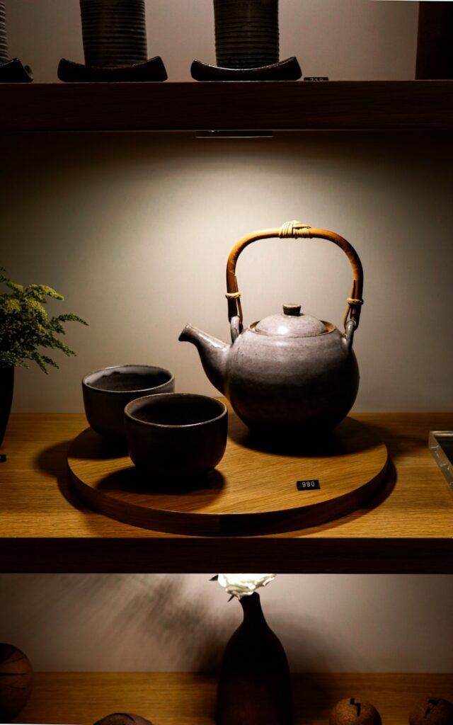 A shelf with a tea pot and two cups on it