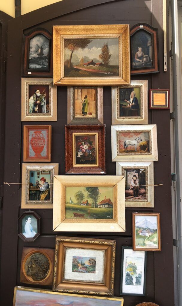 a wall with many framed pictures on it