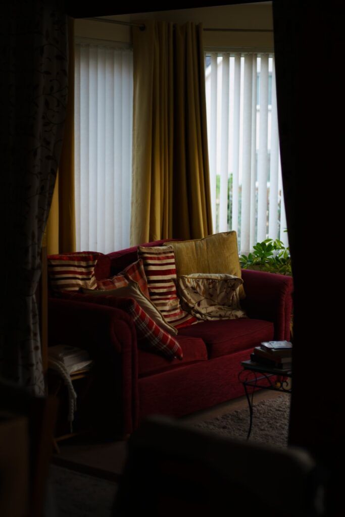 a living room with a red couch and curtains