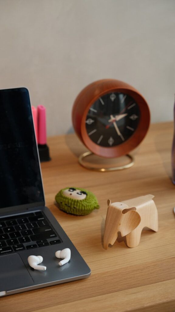 A laptop, clock, and various decorations on a desk.