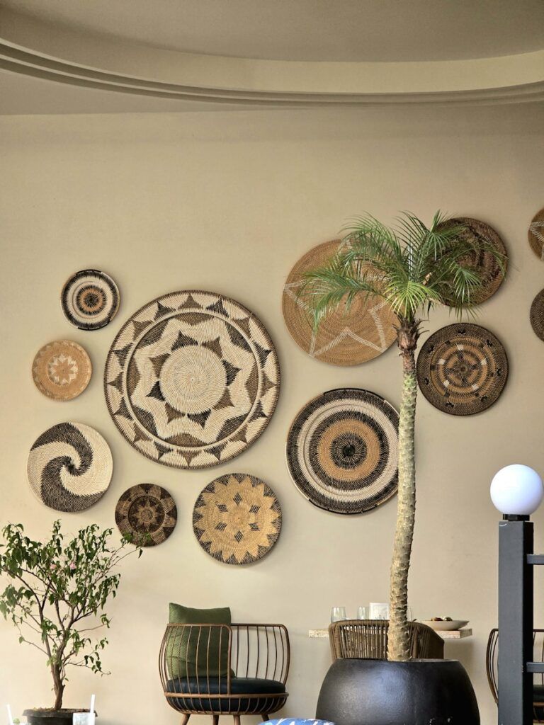Woven wall hangings and a potted palm tree.