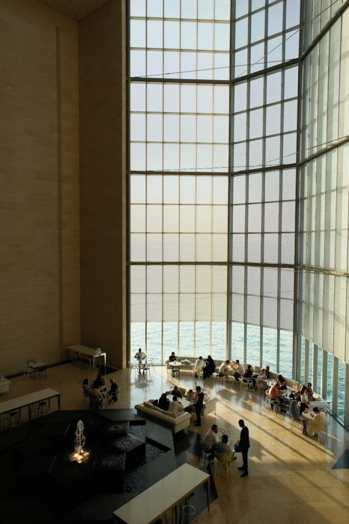 People relaxing in a modern atrium with large windows