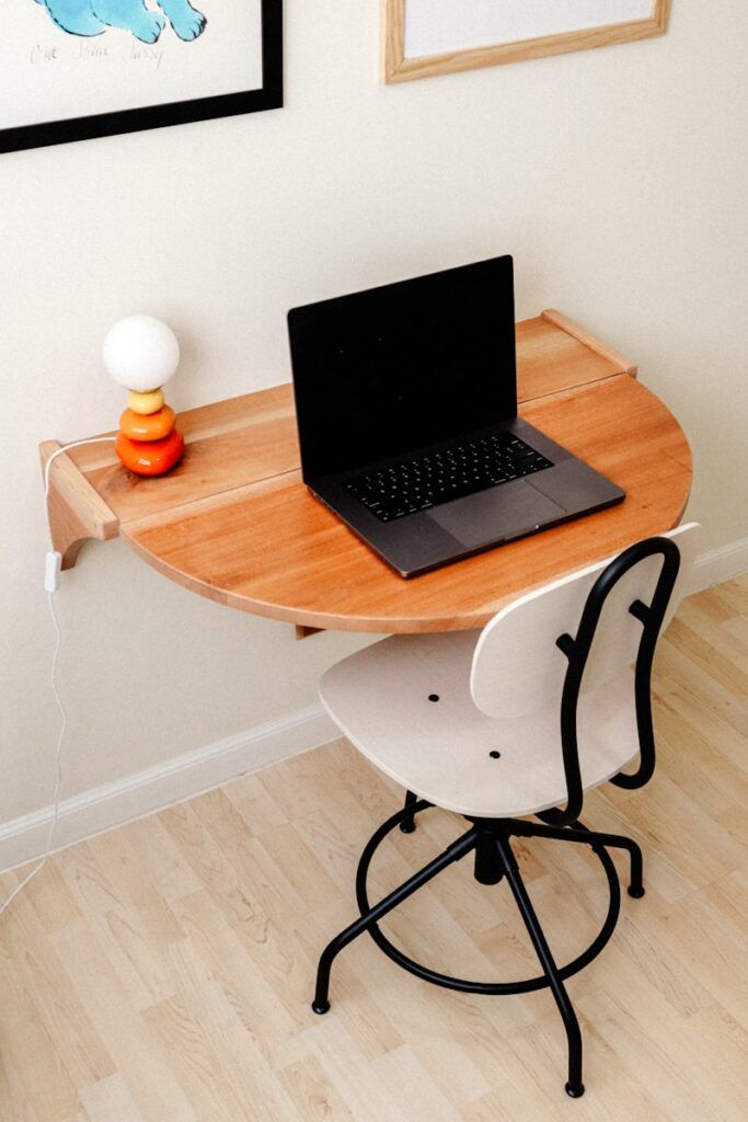 a laptop computer sitting on top of a wooden desk