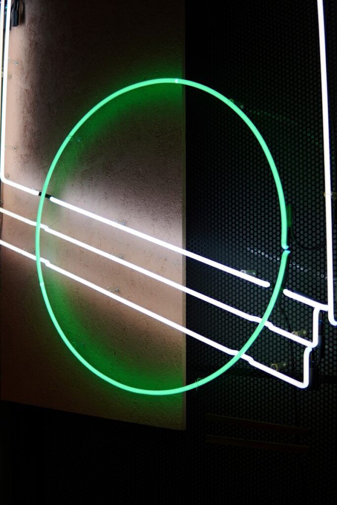 a green neon circle on a black wall