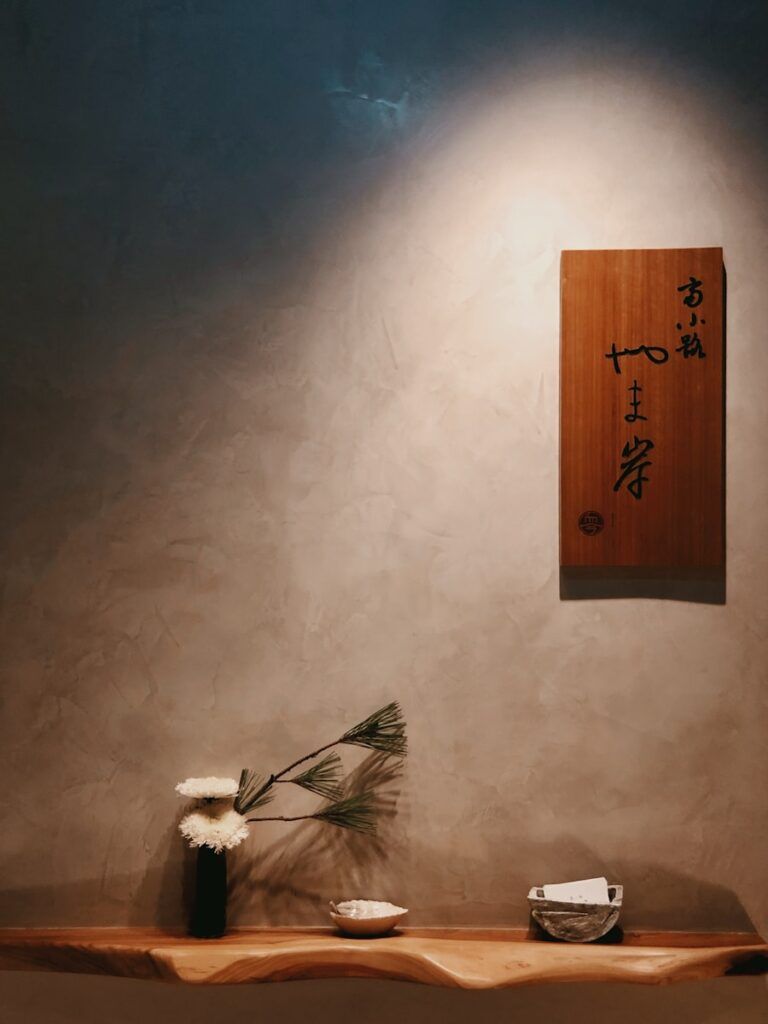 a wooden shelf with a vase and flowers on it