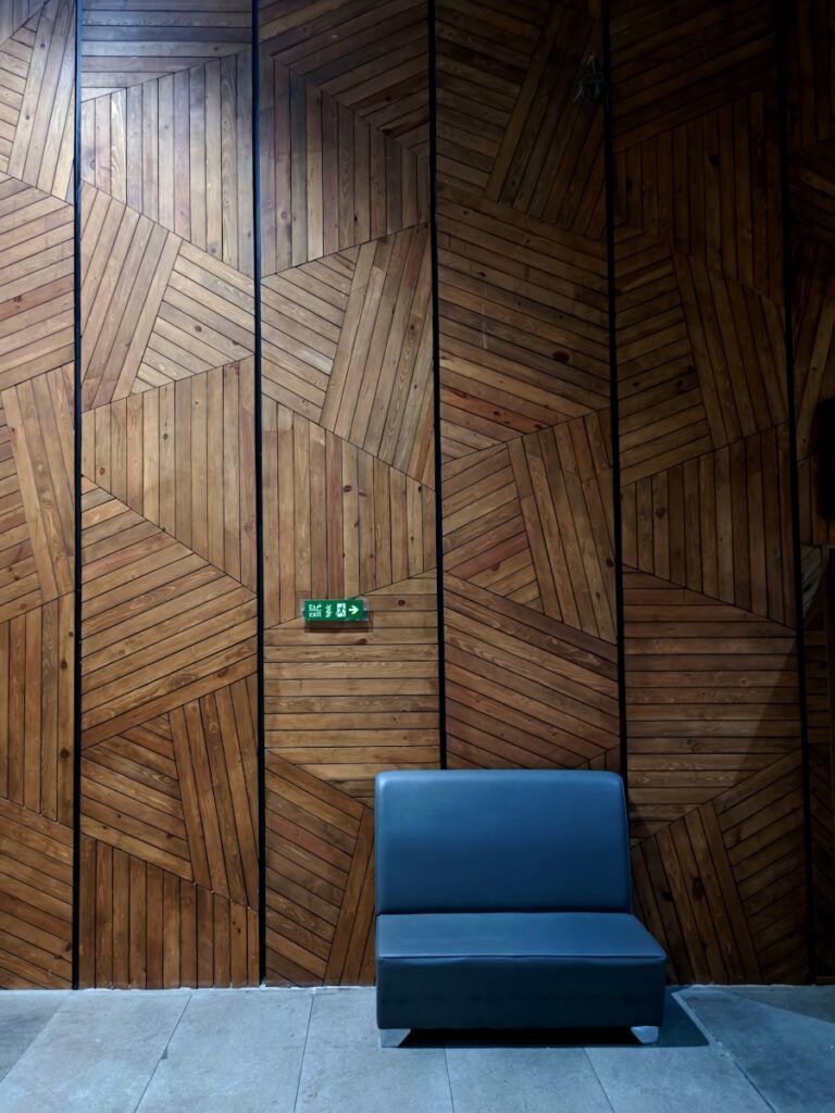 A blue chair sitting in front of a wooden wall