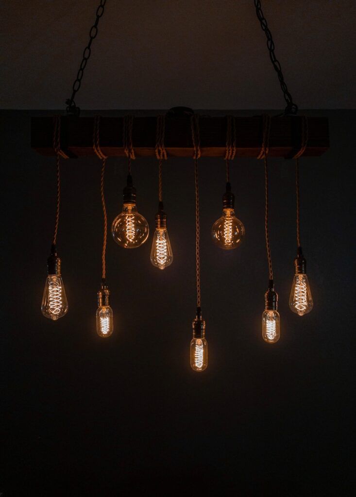 a bunch of vintage light bulbs hanging from a light fixture