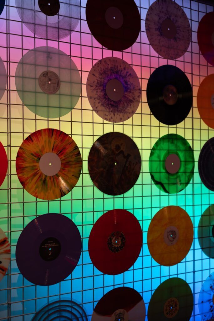 Colorful vinyl records displayed on a grid wall.