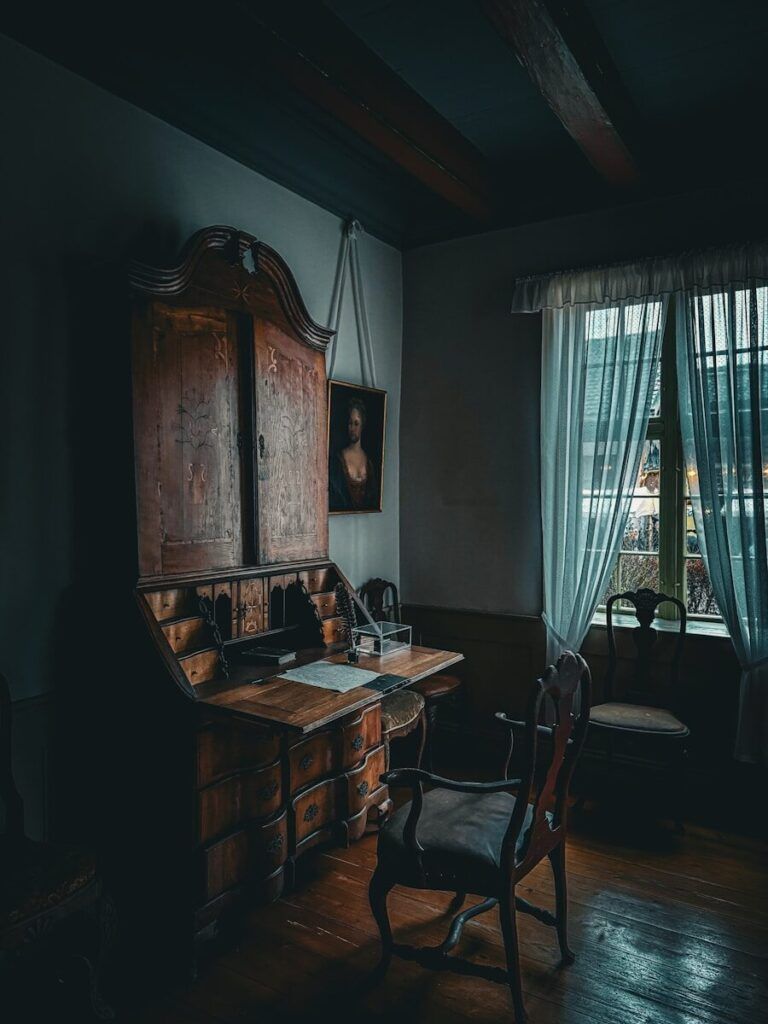 A dark, old-fashioned desk in a dimly lit room.