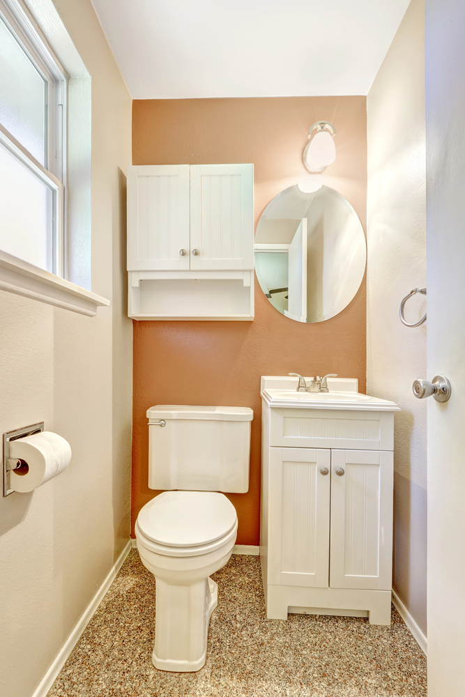 orange-painted accent wall in a small bathroom