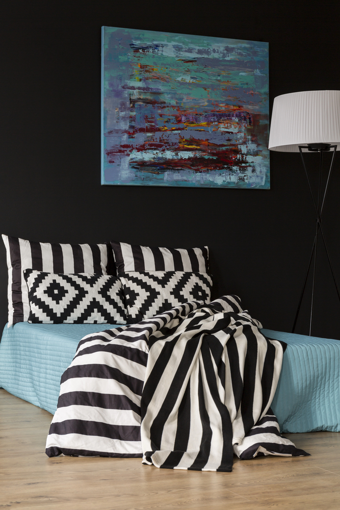 Black Bedroom with Graphic Patterns and Colorful Artwork