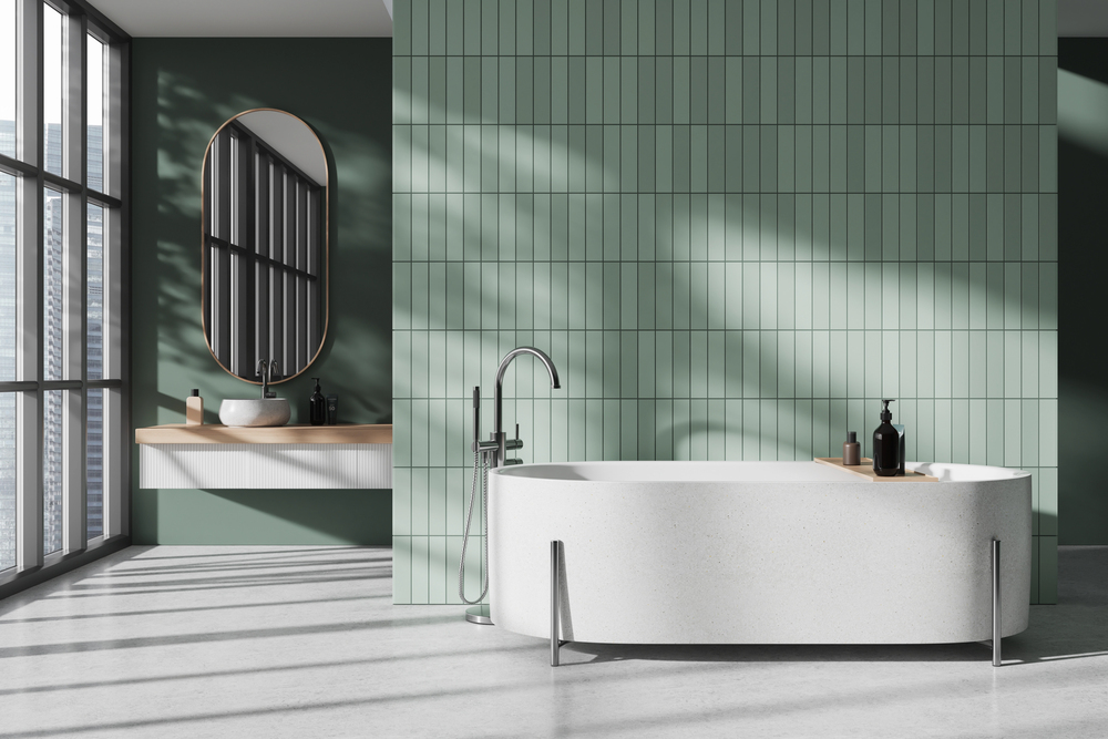 green tile bathroom wall behind a tub in a contemporary bathroom