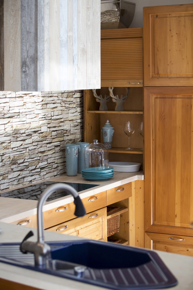Warm Wood Cabinets With a Rustic Stone Backsplash