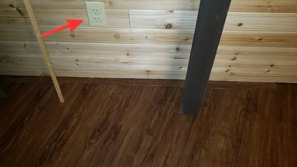 Cedar planks notched neatly around an electrical outlet