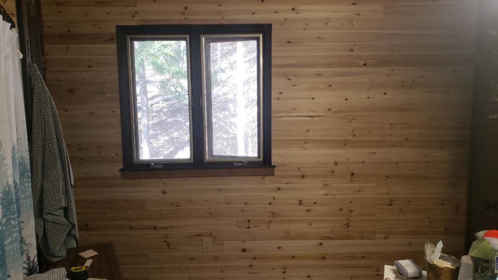 The full bathroom wall covered in natural cedar planks, freshly installed