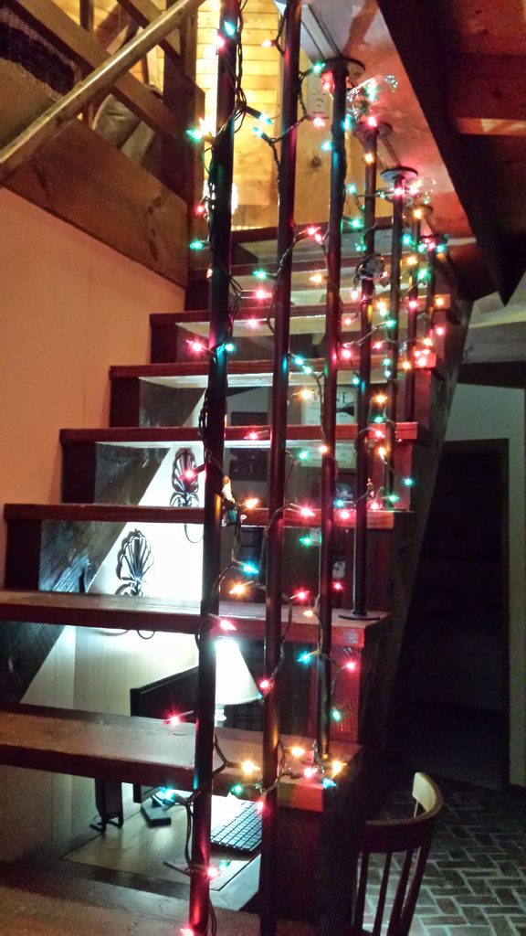 Christmas Lights Wrapped Around a Rustic Staircase